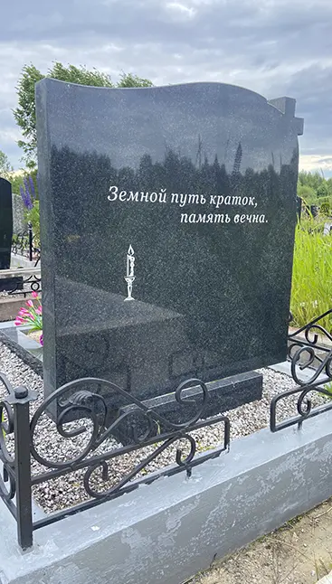 Установленный двойной памятник из черного гранита с эпитафией и изображением свечи